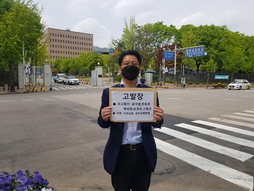 김한메 사법정의바로세우기시민행동 대표가 26일 정부과천청사 정문 앞에서 윤석열 전 검찰총장 등을 정경심 사건 관련 수사권 등 직권남용 혐의로 고발하는 고발장을 들어보이고 있다. 사법정의바로세우기시민행동 제공